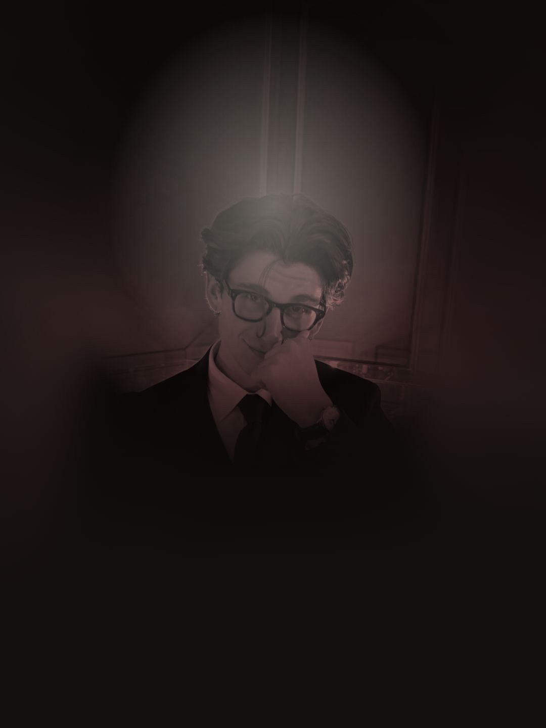 Ritratto di Nikola Greku in giacca scura, trattato in duotone bordeaux.